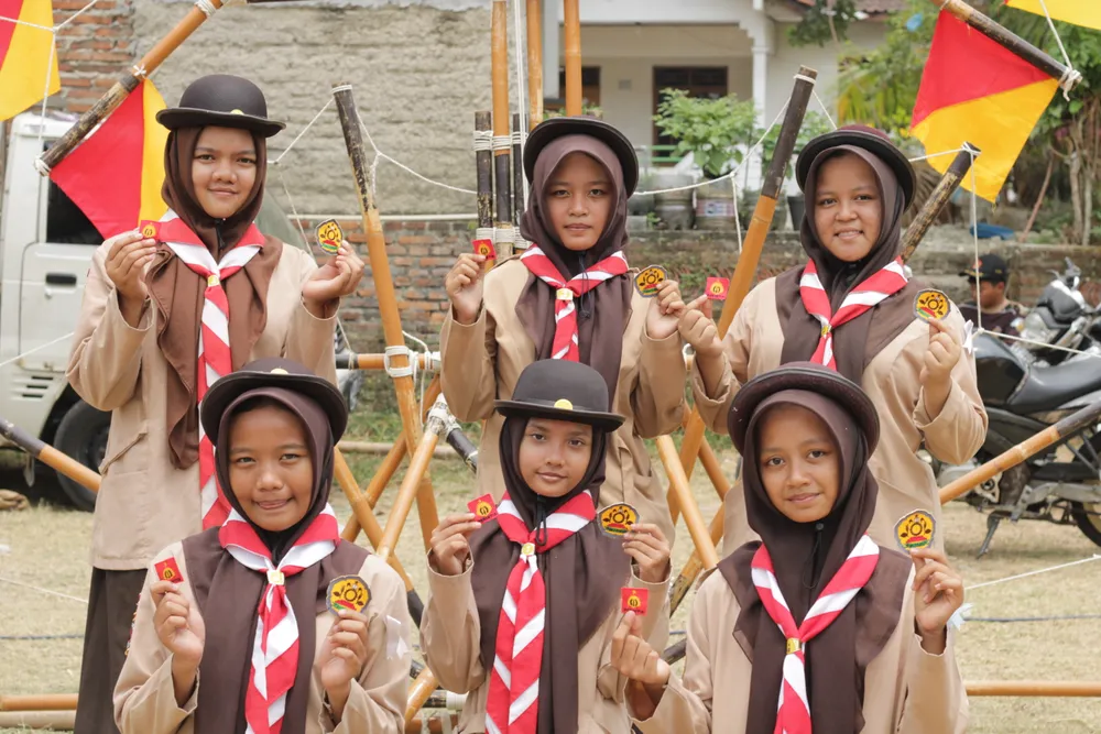 Enam peserta putri berseragam pramuka berfoto bersama di depan konstruksi tongkat